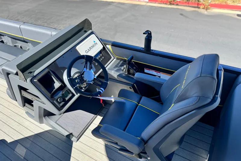 Slide: The Image of 2025 Manitou EXPLORE 24 boat cockpit with Garmin navigation system and comfortable seating. - 23