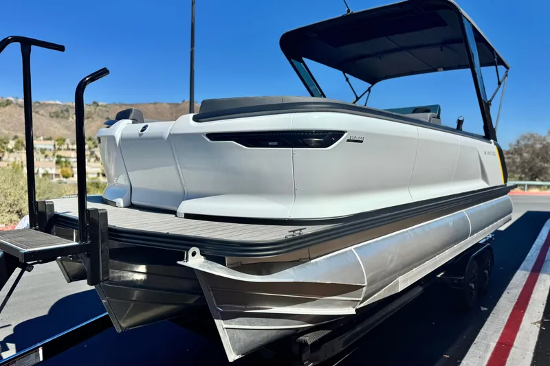 Slide: The Image of 2025 Manitou EXPLORE 24 pontoon boat on trailer, featuring sleek design and modern amenities. - 3