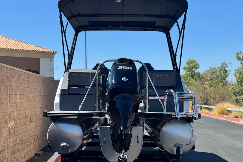Slide: The Image of 2025 Manitou EXPLORE 24 pontoon boat with powerful 300 engine, parked outdoors. - 5