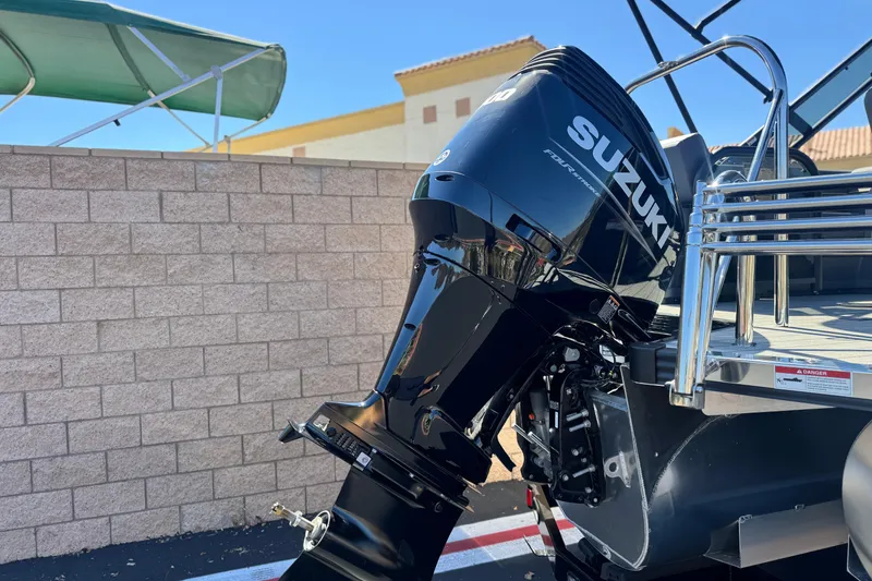 Slide: The Image of Outboard motor on 2025 Manitou EXPLORE 24 boat, featuring Suzuki branding. - 7