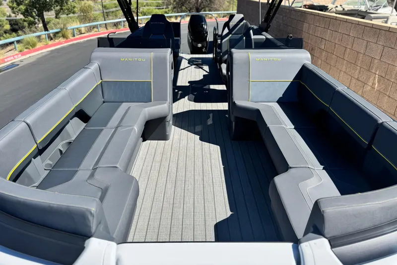 Slide: The Image of 2025 Manitou EXPLORE 24 boat interior with sleek gray seating and modern design. - 8