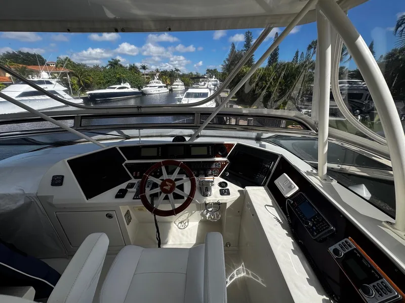 Slide: The Image of Helm of 2006 Marquis 65 yacht with modern controls and scenic marina view. - 10