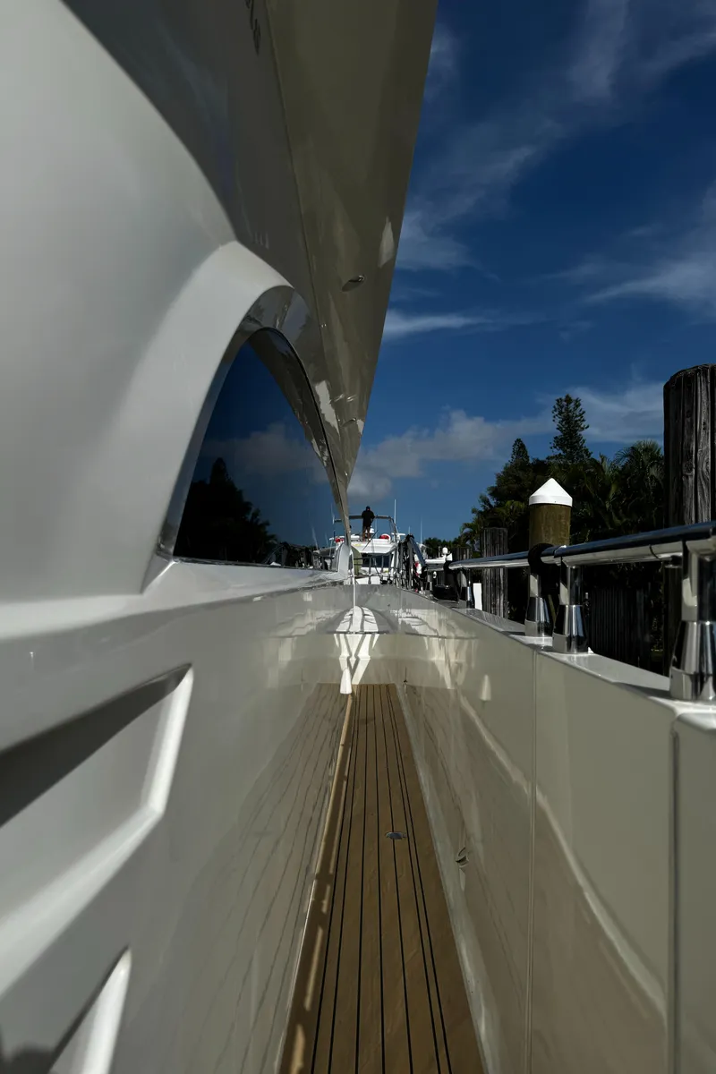 Slide: The Image of Side view of a 2006 Marquis 65 yacht docked under a clear blue sky. - 20