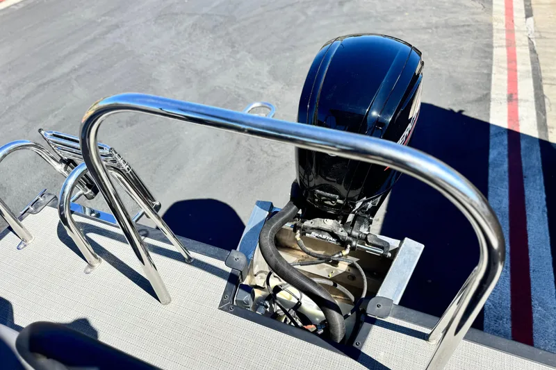 Slide: The Image of 2024 Manitou Cruise 22 boat engine and railing detail. - 16
