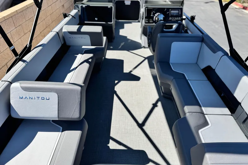 Slide: The Image of 2024 Manitou Cruise 22 pontoon boat interior with gray seating and modern dashboard. - 17