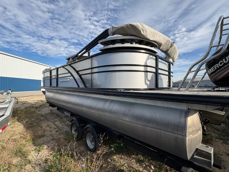 Slide: The Image of 2018 Starcraft CX 23 RE pontoon boat on trailer, under a partly cloudy sky. - 13