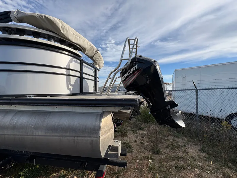 Slide: The Image of 2018 Starcraft CX 23 RE pontoon boat with Mercury outboard motor, parked outdoors. - 14