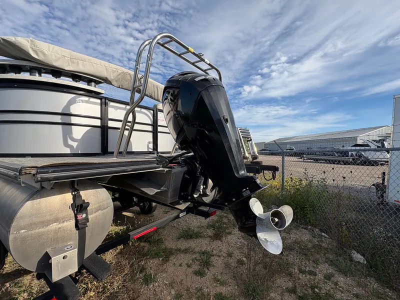 Slide: The Image of 2018 Starcraft CX 23 RE pontoon boat with outboard motor, parked outdoors. - 15