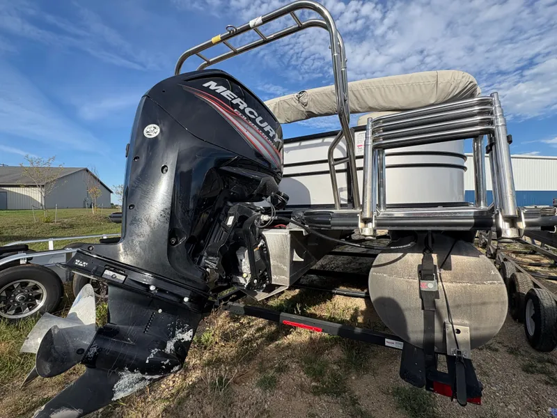 Slide: The Image of 2018 Starcraft CX 23 RE pontoon boat with Mercury outboard motor, parked on trailer. - 16