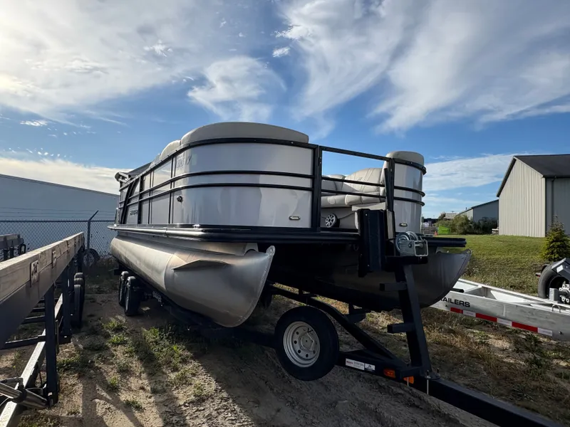 Slide: The Image of 2018 Starcraft CX 23 RE pontoon boat on trailer under a blue sky. - 2