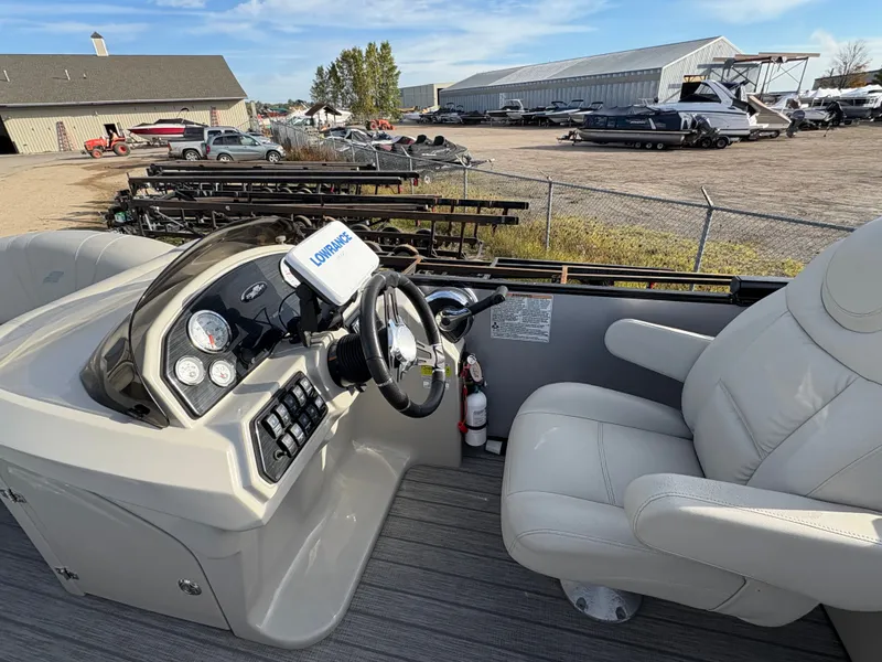 Slide: The Image of 2018 Starcraft CX 23 RE boat interior with steering console and comfortable seating. - 7