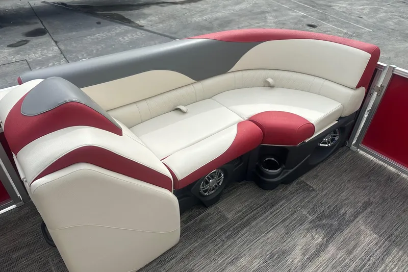 Slide: The Image of 2024 Avalon LSZ 2385 VRB boat interior with red and white seating, cup holders, and speakers. - 11