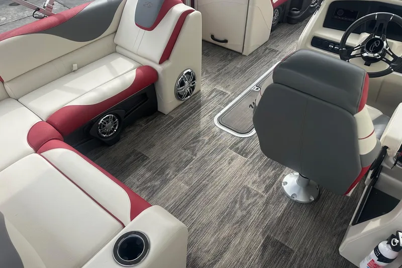 Slide: The Image of 2024 Avalon LSZ 2385 VRB boat interior with red and white seating, modern steering, and wood-style flooring. - 12