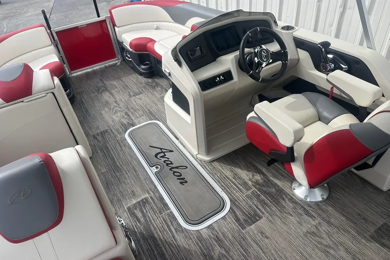 Slide: The Image of 2024 Avalon LSZ 2385 VRB boat interior with red and white seating, modern helm, and wood-style flooring. - 13