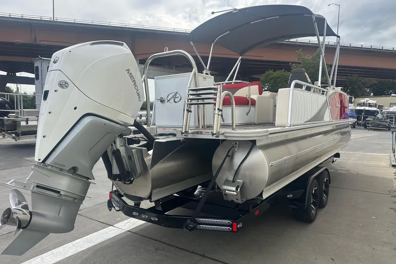Slide: The Image of 2024 Avalon LSZ 2385 VRB pontoon boat with Mercury outboard motor, docked under overpass. - 3
