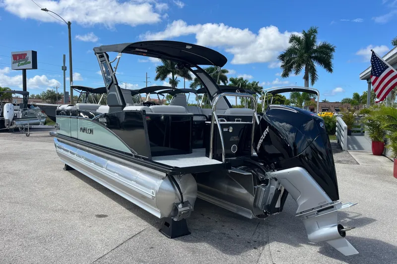 Slide: The Image of 2026 Avalon 2385 Catalina Quad Lounger Tri Toon boat with American flag, parked outdoors. - 8