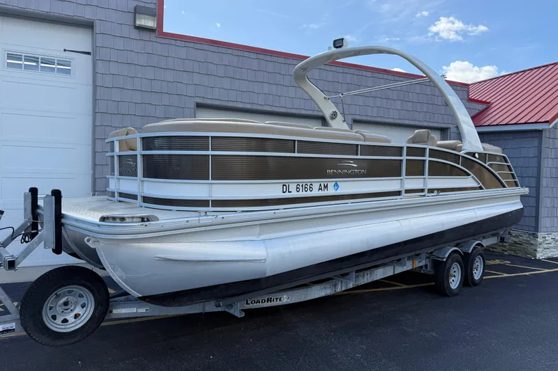 Slide: The Image of 2016 Bennington 2550 RSF Arch Tri Toon pontoon boat on trailer, parked outside. - 1