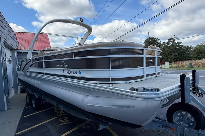 Slide: The Image of 2016 Bennington 2550 RSF Arch Tri Toon boat on trailer, parked outdoors. - 10