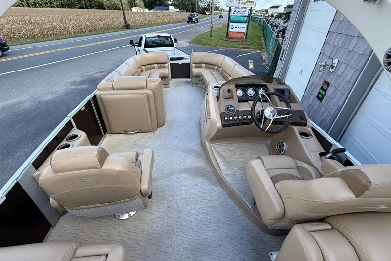Slide: The Image of 2016 Bennington 2550 RSF Arch Tri Toon boat interior with beige seating and steering console. - 16