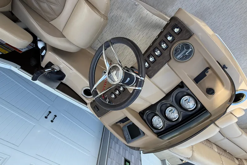 Slide: The Image of 2016 Bennington 2550 RSF Arch Tri Toon dashboard with steering wheel and controls. - 27