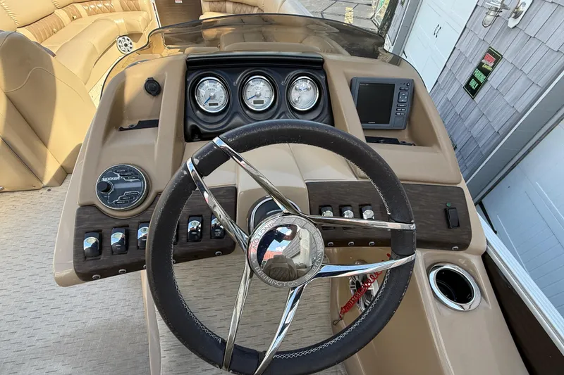 Slide: The Image of Steering console of 2016 Bennington 2550 RSF Arch Tri Toon boat, featuring gauges and controls. - 28