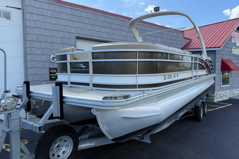 Slide: The Image of 2016 Bennington 2550 RSF Arch Tri Toon pontoon boat on trailer, parked outside building. - 3