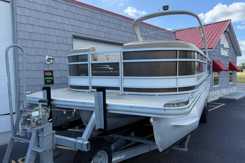 Slide: The Image of 2016 Bennington 2550 RSF Arch Tri Toon boat on trailer near building. - 4