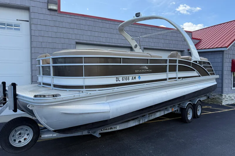 Slide: The Image of 2016 Bennington 2550 RSF Arch Tri Toon pontoon boat on trailer, parked outside. - 5
