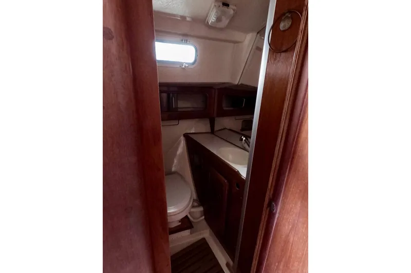Slide: The Image of Compact bathroom in 1985 Mirage 35 sailboat with wooden cabinetry and small window. - 10