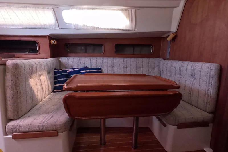Slide: The Image of 1985 Mirage 35 yacht interior with cozy seating and wooden table. - 13