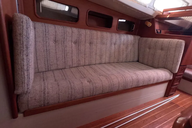 Slide: The Image of Interior of 1985 Mirage 35 sailboat with cushioned seating and wooden accents. - 14