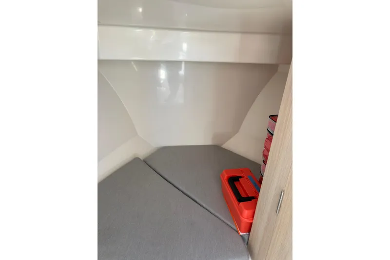 Slide: The Image of 2023 Bayliner Trophy T25 Pilothouse cabin interior with storage and seating area. - 11