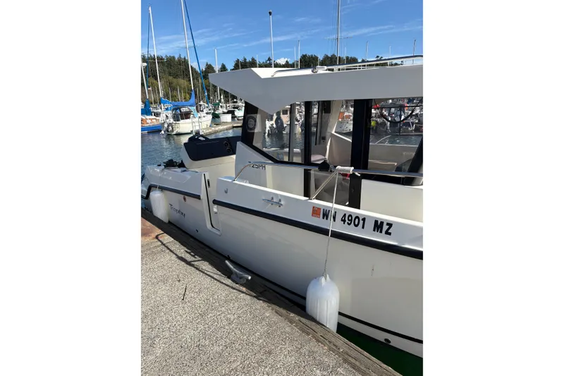 Slide: The Image of 2023 Bayliner Trophy T25 Pilothouse docked at marina, side view. - 13