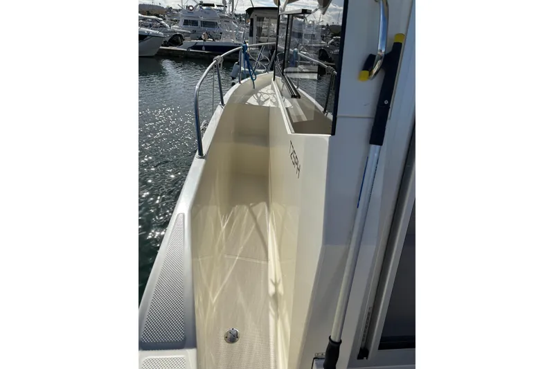 Slide: The Image of 2023 Bayliner Trophy T25 Pilothouse boat docked, showcasing sleek side deck design. - 4