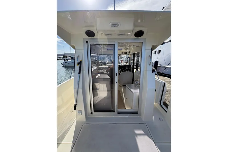 Slide: The Image of 2023 Bayliner Trophy T25 Pilothouse interior with sliding door and helm view. - 5