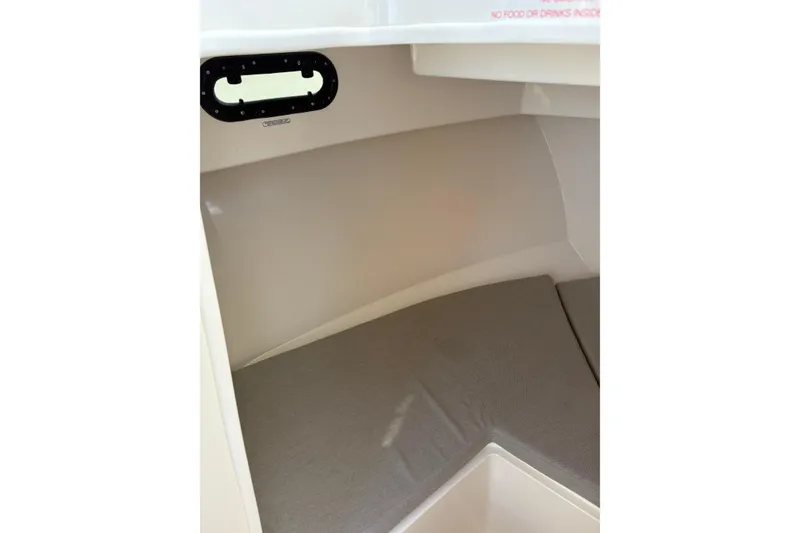 Slide: The Image of 2023 Bayliner Trophy T25 Pilothouse interior cabin with cushioned seating. - 7