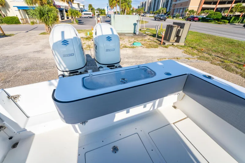 Slide: The Image of 1997 Contender 27 boat with dual Suzuki 200 engines, parked near a street. - 11