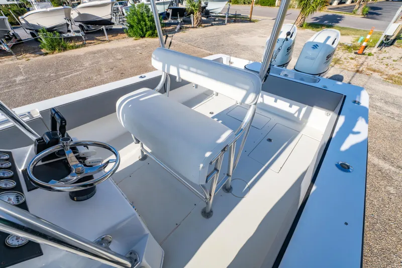 Slide: The Image of 1997 Contender 27 boat interior with steering wheel, seating, and dual Suzuki engines. - 13