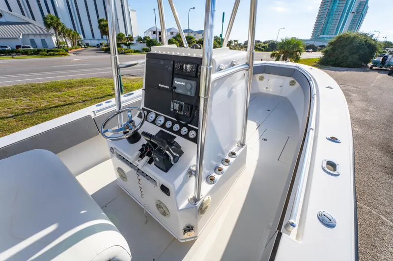 Slide: The Image of 1997 Contender 27 boat interior with steering console and modern controls, docked near buildings. - 15