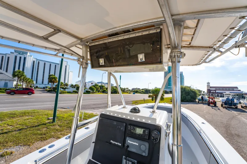 Slide: The Image of 1997 Contender 27 boat with Raymarine electronics, parked near a coastal road and buildings. - 16