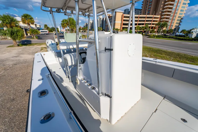 Slide: The Image of 1997 Contender 27 boat interior with seating and console, parked near palm trees and buildings. - 17