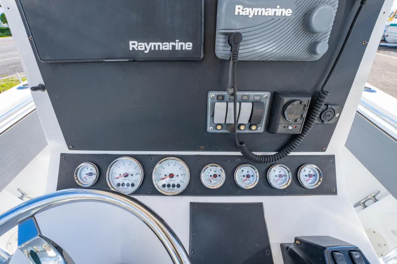 Slide: The Image of 1997 Contender 27 boat dashboard with Raymarine electronics and multiple gauges. - 25