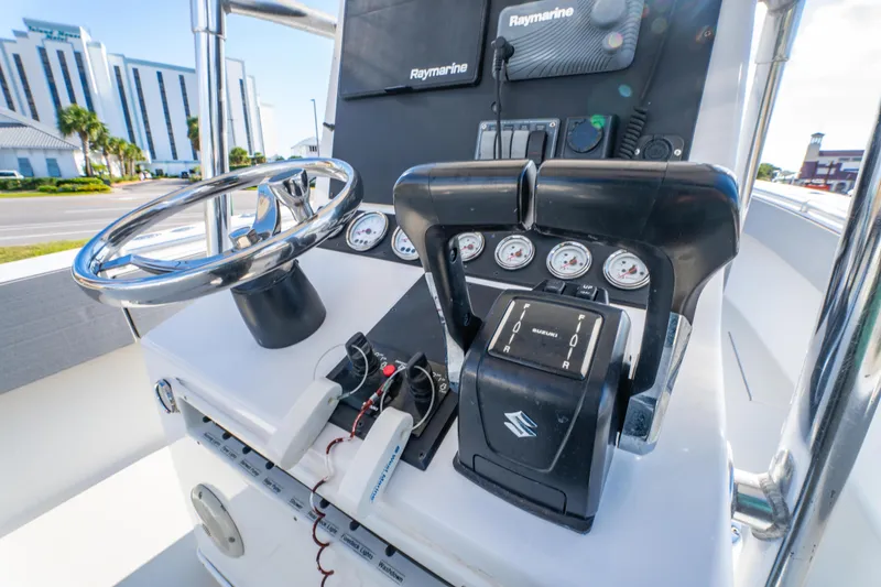 Slide: The Image of Control panel of a 1997 Contender 27 boat with steering wheel and gauges. - 26