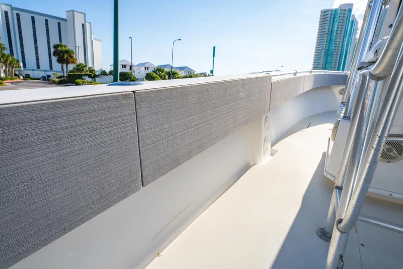 Slide: The Image of 1997 Contender 27 boat deck with cityscape background, featuring modern railings and padded sides. - 27