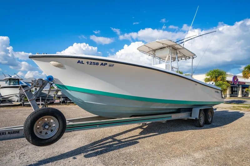 Slide: The Image of 1997 Contender 27 boat on trailer under blue sky, side view. - 7