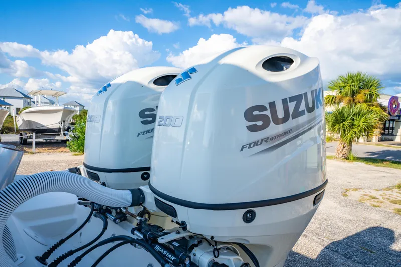 Slide: The Image of Twin Suzuki 200 outboard engines on a 1997 Contender 27 boat under a blue sky. - 8
