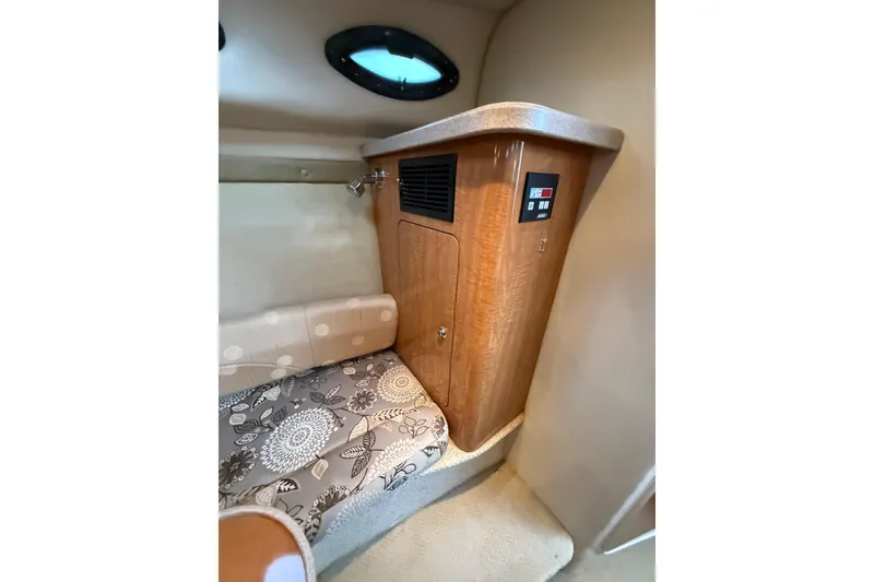 Slide: The Image of 2004 Regal Commodore 2765 cabin interior with wood cabinet and patterned seating. - 12