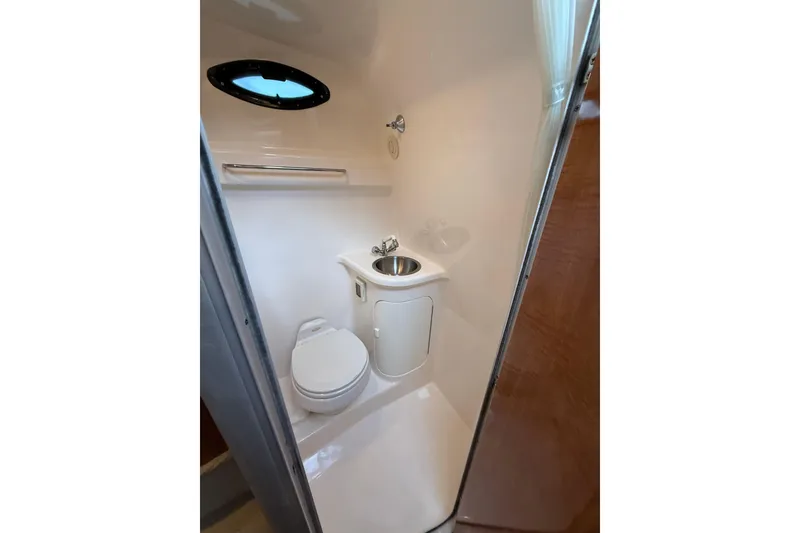 Slide: The Image of Compact bathroom in 2004 Regal Commodore 2765 boat with toilet, sink, and porthole. - 13
