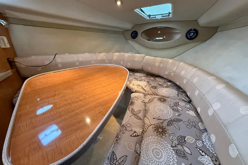 Slide: The Image of 2004 Regal Commodore 2765 cabin interior with cushioned seating and wooden table. - 14