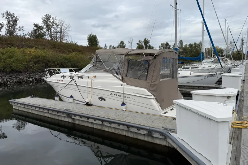 Slide: The Image of 2004 Regal Commodore 2765 boat docked at marina with canopy cover. - 2